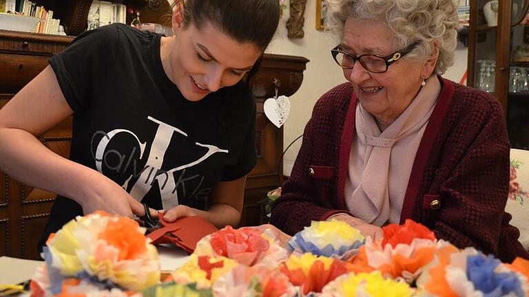 Chiara Lang lernt heute von Lilian Eisenmann, Rosen aus bunten Papierservietten herzustellen.