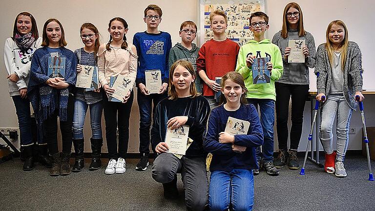 Die zehn Kreissieger (im Hintergrund) und die beiden Gewinnerinnen auf Bezirksebene: Josephine Uhlich (vorne links) und Magdalena Lang (vorne rechts) vertreten Unterfranken beim Landesfinale des Vorlesewettbewerbs.