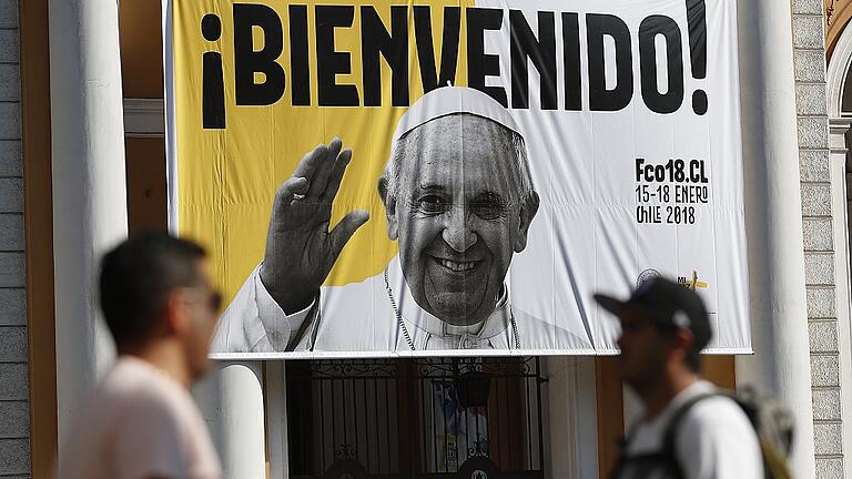 Vor dem Papstbesuch in Chile       -  Passanten in Santiago de Chile vor einem Plakat, auf dem Papst Franziskus willkommen geheißen wird. Franziskus wird vom 15. bis zum 18. Januar Chile bereisen.Francisco Flores, dpa