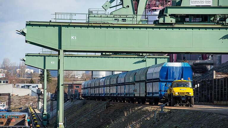 Das Zwei-Wege-Fahrzeugs ist im Hafen als Rangierlock auf den Schienen, auf Pflaster und Asphalt unterwegs und kann Waggons mit einem Gesamtgewicht von bis zu 6000 Tonnen ziehen. Über ihm sind die Stützen der Doppelwippkräne zu sehen. Das Zwei-Wege-Fahrzeugs ist im Hafen als Rangierlock auf den Schienen, auf Pflaster und Asphalt unterwegs und kann Waggons mit einem Gesamtgewicht von bis zu 6000 Tonnen ziehen. Über ihm sind die Stützen der Doppelwippkräne zu sehen.