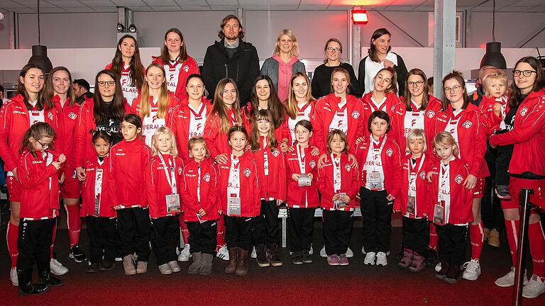 Kicken ab der neuen Saison im Namen der Rothosen: Die Mädchen und Frauen des SC Würzburg (hinten: Kickers-Vorstandsvorsitzender Daniel Sauer und Gudrun Reinders, die Vorsitzende des neu gegründeten FC Würzburger Kickers - Mädchen- und Frauenfußball' e.V..