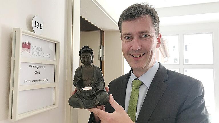 Ganz gelassen: Würzburgs Oberbürgermeister Christian Schuchardt mit einem Buddha vor dem Besprechungsraum &bdquo;Otsu&ldquo; im Rathaus.