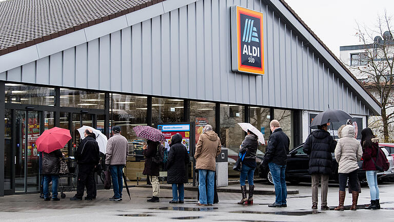 Zahlreiche Kunden stehen kurz vor Ladenöffnung vor einem Markt von ALDI Süd.