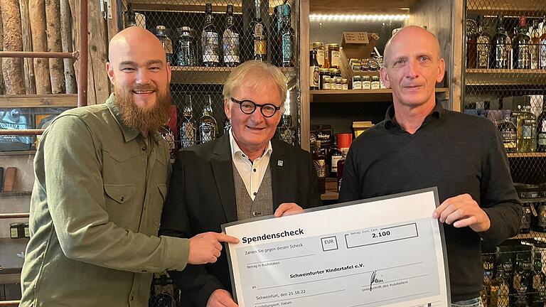 Wenn Menschen an andere, bedürftige Menschen denken: Dr. Jürgen Schiemann (rechts) überreichte zusammen mit Patrick James vom Geschäft Whiskey Gents/ Montana (links) einen Spendenscheck in Höhe von 2100 Euro an den Vorsitzenden der Schweinfurter Kindertafel, Stefan Labus.