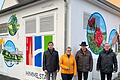 Johannes Haimann (Entwurfsfertiger), Ingrid Haimann (Vorsitzende AK 1200-Jahrfeier), Herbert Hemmelmann (Erster Bürgermeister) und Frank Schneider (Bayernwerk AG) vor der bemalten Trafostation in Himmelstadt.