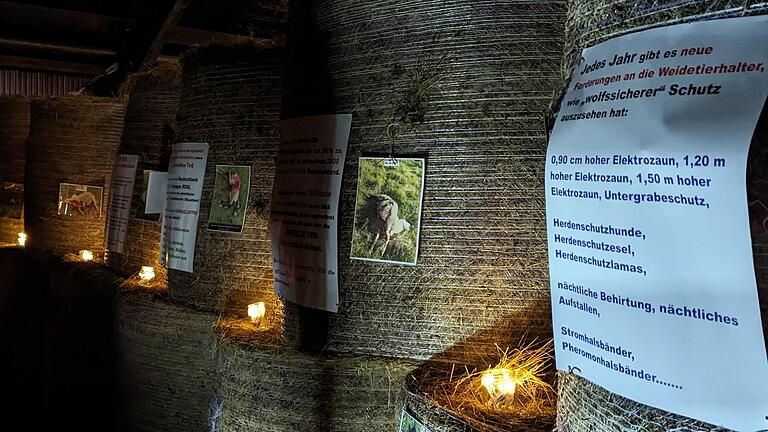 Gestapelte Heuballen mit Bildern von gerissenen Schafen bildeten die Kulisse der Mahnwache in Ginolfs.