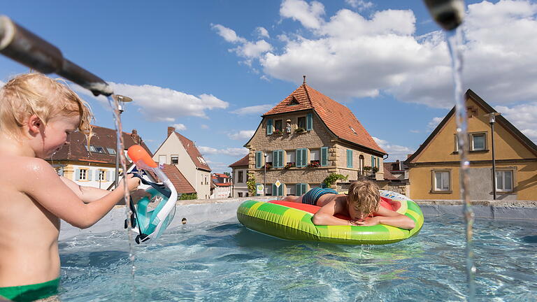 Zwei Brüder planschen bei 29 Grad Außentemperatur im Dorfbrunnen von Escherndorf. Zwei Brüder planschen bei 29 Grad Außentemperatur im Dorfbrunnen von Escherndorf. 