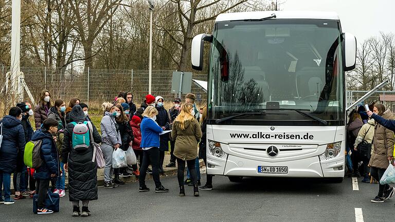 Es ist ein Kommen und Gehen: Tag und Nacht fahren Busse in der unterfränkischen Anker-Einrichtung vor, um neue Flüchtlinge zu bringen oder schon registrierte in umliegende Unterkünfte zu fahren.