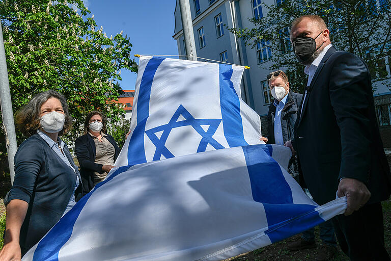 Solidarität mit Israel: Am Freitag hisste Landrat Thomas Eberth (vorne rechts) wieder die israelische Nationalflagge vor dem Würzburger Landratsamt. Dabei wurde er unterstützt von (von links) Landtagsabgeordnete und Kreisrätin Kerstin Celina (Bündnis90/Die Grünen), Isabell Schumacher, Partnerschaftsbeauftragte des Landkreises und Jürgen Eisentraut . Solidarität mit Israel: Am Freitag hisste Landrat Thomas Eberth (vorne rechts) wieder die israelische Nationalflagge vor dem Würzburger Landratsamt. Dabei wurde er unterstützt von (von links) Landtagsabgeordnete und Kreisrätin Kerstin Celina (Bündnis90/Die Grünen), Isabell Schumacher, Partnerschaftsbeauftragte des Landkreises und Jürgen Eisentraut . 