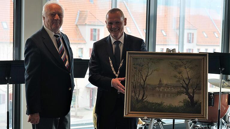 Festredner Leonhard Scherg überreicht Bürgermeister Thomas Stamm ein Gemäde einer Stadtansicht von Marktheidenfeld als Geschenk