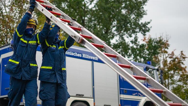 Das sichere Anlegen einer Leiter wird geprüft. Wegen Corona müssen die Prüflinge Mundschutz tragen.