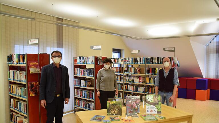 Bürgermeister Harald Hofmann (von links), Vorsitzende OGV Brigitte May und Büchereileiter Hubert Ziegler freuen sich über die Bücherspende.  B.Hein/Gemeindeverwaltung       -  Bürgermeister Harald Hofmann (von links), Vorsitzende OGV Brigitte May und Büchereileiter Hubert Ziegler freuen sich über die Bücherspende.  B.Hein/Gemeindeverwaltung