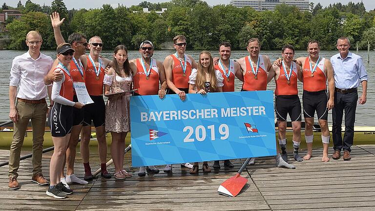 Das Bild zeigt den siegreichend Mastersachter mit den Vertretern des Bayerischen Ruderverbandes, Johannes Rauh (links) und Thomas Stamm (rechs)