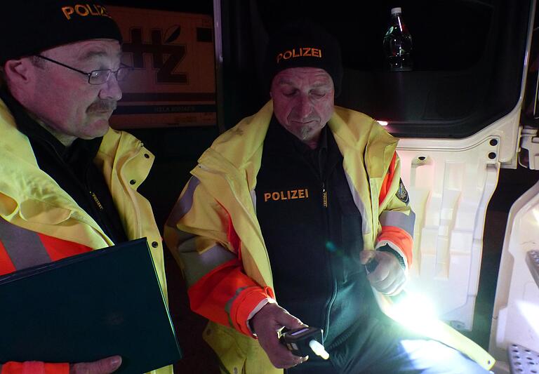 Zwei Polizeibeamte überprüfen einen Laster-Fahrer, der gerade in das Alko-Testgerät gepustet hat. Zwei Polizeibeamte überprüfen einen Laster-Fahrer, der gerade in das Alko-Testgerät gepustet hat.