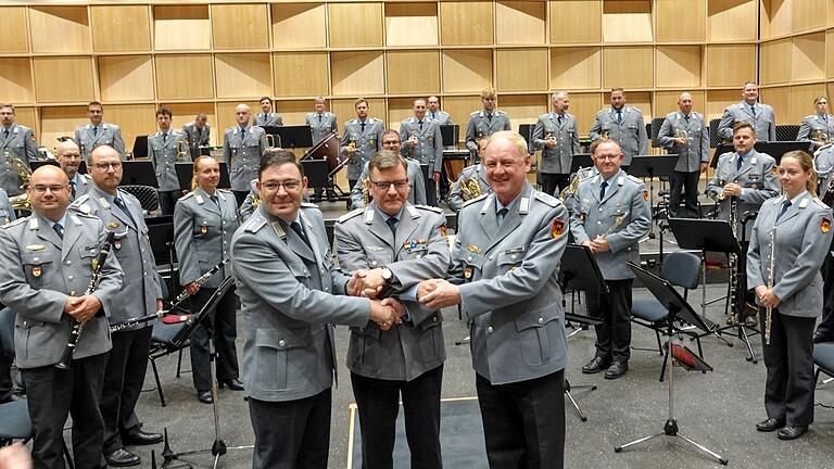 Der Stellvertretende Leiter des Zentrums Militärmusik der Bundeswehr Oberst Christoph Scheibling (Mitte) übergab im nagelneuen Probensaal der Bundeswehrmusiker in der Balthasar-Neumann-Kaserne  den Taktstock und damit  das Kommando über das Heeresmusikkorps (HMK) Veitshöchheim von Oberstleutnant Roland Kahle (rechts) an seinen Nachfolger Hauptmann Wolfgang Dietrich (links).