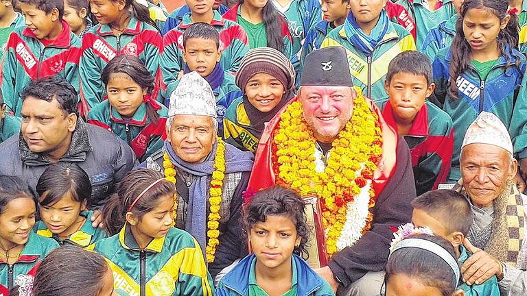 Willkommensfreude: Mit Blumenkränzen als Zeichen der Dankbarkeit wurde Klaus Meyer bei seinem letzten Besuch in Nepal empfangen. Im Bild ist er zusammen mit Freunden und Schülern der Schule zu sehen, für dessen Aufbau er sich seit 13 Jahren engagiert.