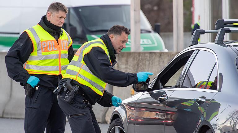 Bundesolizisten kontrollieren an der Autobahn-Übergangsstelle Kiefersfelden die Insassen der herausgewunkenen Pkw. Mit Einreiseverboten und strengen Grenzkontrollen will Deutschland von Montag an die Ausbreitung des Coronavirus weiter eindämmen.