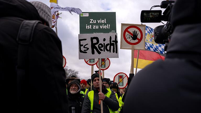 Bauernproteste – Großkundgebung in Berlin.jpeg - Ein Teilnehmer der Protestdemonstration hält während der Kundgebung vor dem Brandenburger Tor Schilder hoch. Bauernproteste – Großkundgebung in Berlin.jpeg - Ein Teilnehmer der Protestdemonstration hält während der Kundgebung vor dem Brandenburger Tor Schilder hoch.