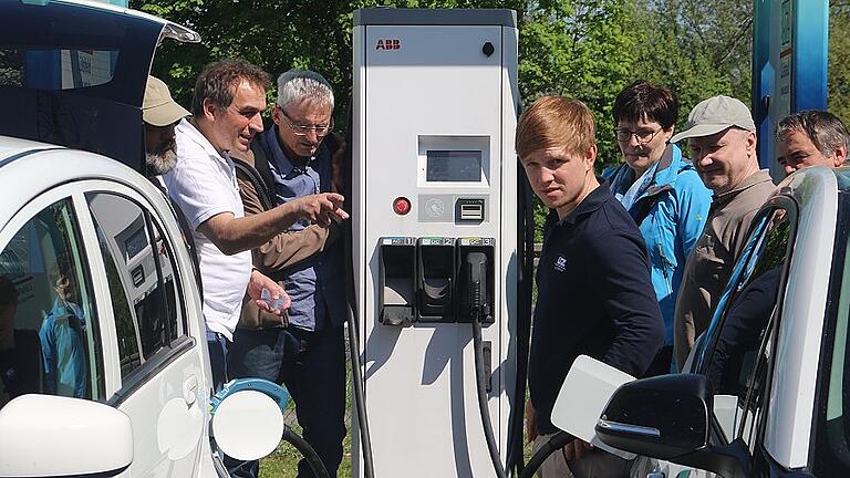 Energieberater Günther Lieberth (links) und Andreas Ebert, bei der Überlandzentrale Lülsfeld zuständig für Elektromobilität (4. von rechts) erläuterten die verschiedenen Varianten der Ladesäulen am Euro-Rastpark in Knetzgau.