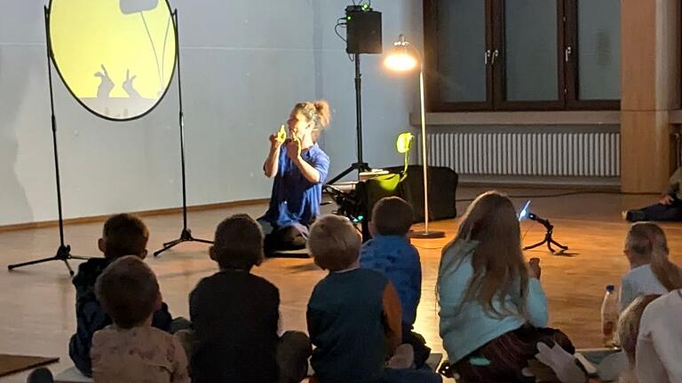 Begeisterte Zuschauer:innen beim Handschattentheater im Pfarrsaal 'Zur Hl. Familie'.