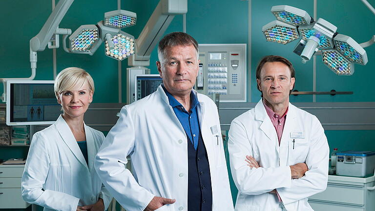 0002285179.jpg       -  So kennt man das Team aus der ARD-Serie „In aller Freundschaft“: Dr. Kathrin Globisch (gespielt von Andrea Kathrin Loewig), Dr. Roland Heilmann (Thomas Rühmann) und Dr. Martin Stein (Bernhard Bettermann).