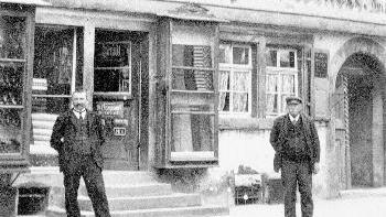 Geschäftsgründer Peter Wendel (rechts) mit       -  Geschäftsgründer Peter Wendel (rechts) mit seinem Sohn Eugen vor ihrem
Geschäft in der oberen Hauptstraße, heute Hausnummer 71. Auf dem
Firmenschild über dem Geschäft stand 'Färberei v. Peter Wendel, Lager in
allen Sorten, Schuhlager, Schnittwaren, Kurzwaren, Seife und Lichter'. Das
Foto entstand um 1910.