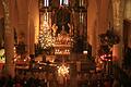 Kerzenschein erfüllt die Stadtpfarrkirche in Gerolzhofen während der gut besuchten Christmette an Heiligabend.