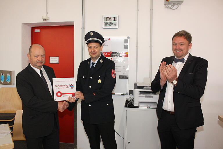 Statt einem klassischem Schlüssel für das neue Feuerwehrgerätehaus überreichter Planer Rüdiger Amthor (rechts) Bürgermeister Herbert Hemmelmann (links) eine Gedenktafel, die dieser gleich an den Kommandanten Joachim Zürn weiter gab. Statt einem klassischem Schlüssel für das neue Feuerwehrgerätehaus überreichter Planer Rüdiger Amthor (rechts) Bürgermeister Herbert Hemmelmann (links) eine Gedenktafel, die dieser gleich an den Kommandanten Joachim Zürn weiter gab.