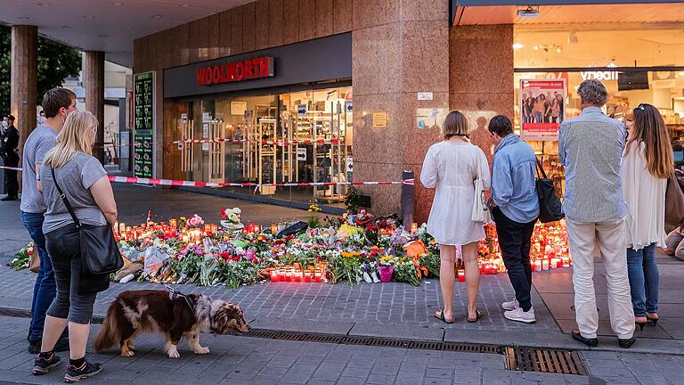 Die Bestürzung ist groß über die Bluttat am Barbarossaplatz in Würzburg. Zahlreiche Menschen geben ihrer Trauer Ausdruck, zünden Kerzen an und legen vor dem Kaufhaus in der Innenstadt Blumen nieder zum Gedenken an die Opfer.