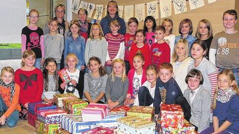 29 Pakete kamen für die Aktion &bdquo;Weihnachten im Schuhkarton&ldquo; in der Grundschule Brendlorenzen zusammen: Das Foto zeigt den Schulchor mit (hinten von links): Direktorin Gudrun Schuhmann, Fachlehrerin Michaela Hausmann und stellvertretende Direktorin Kristina Büsker.