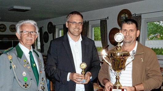 Der &bdquo;Rauhenebrachpokal&ldquo; ging an die FFW Geusfeld. Vorsitzender Ludwig Popp (rechts) nahm die Trophäe von Manfred Weigl (links) und Bürgermeister Matthias Bäuerlein entgegen.