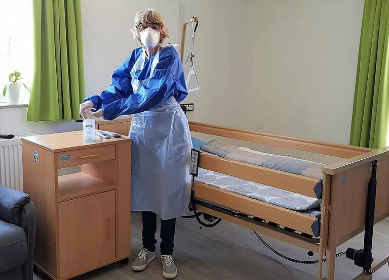 Auch die Caritas-Sozialstationen in Rhön-Grabfeld bewältigen derzeit besondere Herausforderungen, um die ambulante Pflege älterer und schwerkranker Patienten zu leisten. Im Bild zeigt Sybille Paul, Pflegekraft der Sozialstation St. Kilian, eine komplette Schutzkleidung für Hausbesuche. Auch die Caritas-Sozialstationen in Rhön-Grabfeld bewältigen derzeit besondere Herausforderungen, um die ambulante Pflege älterer und schwerkranker Patienten zu leisten. Im Bild zeigt Sybille Paul, Pflegekraft der Sozialstation St. Kilian, eine komplette Schutzkleidung für Hausbesuche.
