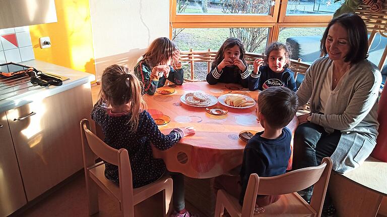 Ute Weiß, Leiterin des Kindergartens St. Michael in Etwashausen, sitzt mit einigen Kindern beim Nachmittagssnack. Ute Weiß, Leiterin des Kindergartens St. Michael in Etwashausen, sitzt mit einigen Kindern beim Nachmittagssnack.