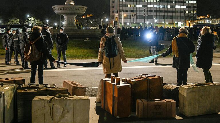 Mit einer Menschenkette stellten sich Vertreterinnen und Vertreter der Würzburger Zivilgesellschaft zwischen eine 'Querdenker'-Versammlung und das Holocaust-Mahnmal am Hauptbahnhof. Mit einer Menschenkette stellten sich Vertreterinnen und Vertreter der Würzburger Zivilgesellschaft zwischen eine 'Querdenker'-Versammlung und das Holocaust-Mahnmal am Hauptbahnhof.