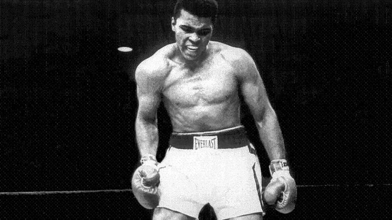 Champion Cassius Clay stands over Sonny Liston and taunts him to get up during the first round of t       -  Muhammad Ali (stehend), der damals noch unter seinem Geburtsnamen Cassius Clay boxte, in einem seiner berühmtesten Kämpfe gegen Sonny Liston 1965.