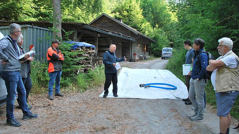 Kreisbrandinspektor Michael Fleder (Mitte) empfiehlt an kritischen Stellen im Gramschatzer Wald fest stationierte Wasserspeicher, wie sie in der Landwirtschaft eingesetzt werden.