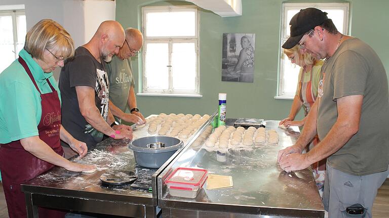 Gemeinschaftliches Backen im neuen Gemeindebackhaus. Die Vorbereitung der Brötchenteiglinge ist echte Handarbeit. Zum Tag der offenen Tür des 'Öberen Bäck' wurden über 100 Brötchen gebacken.