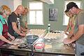 Gemeinschaftliches Backen im neuen Gemeindebackhaus. Die Vorbereitung der Brötchenteiglinge ist echte Handarbeit. Zum Tag der offenen Tür des 'Öberen Bäck' wurden über 100 Brötchen gebacken.