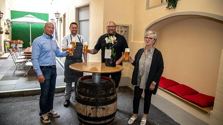 Mario, Alexander und Maria Borst von der Brauerei Roth gratulieren dem neuen Pächter Swen Geis (Zweiter von links) zur Eröffnung des Gasthaus zum Roth. Geis hat sich mit dem fränkischen Gasthaus einen Lebenstraum verwirklicht und auch gleich eine Neuerung eingeführt: Ab sofort gibt es einen Stehausschank im überdachten Bereich der Hofeinfahrt hinter dem markanten Hoftor. Im Hintergrund der bestuhlte Außenbereich im Innenhof des Gasthauses. Mario, Alexander und Maria Borst von der Brauerei Roth gratulieren dem neuen Pächter Swen Geis (Zweiter von links) zur Eröffnung des Gasthaus zum Roth. Geis hat sich mit dem fränkischen Gasthaus einen Lebenstraum verwirklicht und auch gleich eine Neuerung eingeführt: Ab sofort gibt es einen Stehausschank im überdachten Bereich der Hofeinfahrt hinter dem markanten Hoftor. Im Hintergrund der bestuhlte Außenbereich im Innenhof des Gasthauses.