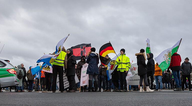 Neben zahlreichen Deutschlandfahnen werden bei den Sonntagsdemonstrationen immer wieder auch Flaggen von rechtsextremen Parteien (rechts) geschwungen.