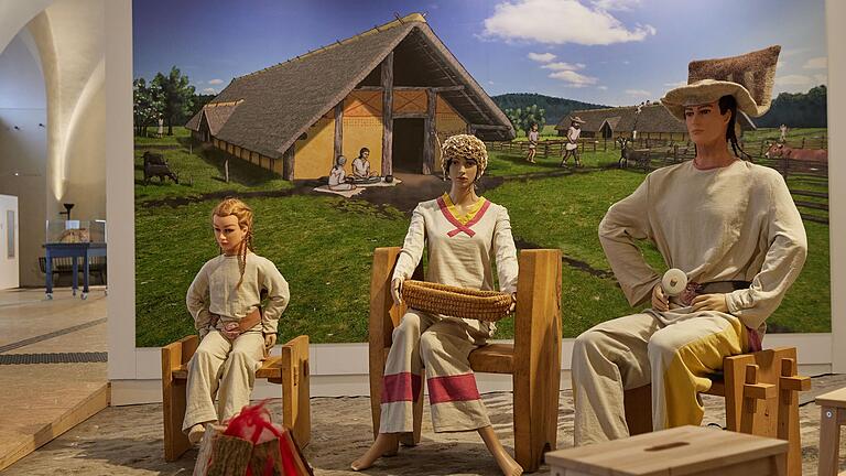 Eine rekonstruierte steinzeitliche Familienszene in der Ausstellung 'Ackern statt Jagen' im Museum für Franken.