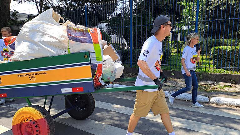 Sebastian Vettel sammelt Müll in Sao Paulo       -  Vettel zieht den Wagen mit dem Müll.