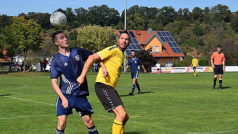 Die Spiele der A-Klassen Rhön       -  Das Kopfball-Duell geht hier an Auras Aaron Gessner, aber der eigentliche Unterschiedsspieler war Wollbachs Marco Krapf (rechts), der seine Elf per Doppelpack in Führung schoss.