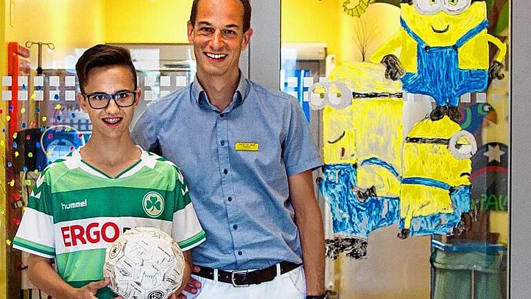 Der ehemalige MDS-Patient Lucas Melchner und Dr. Matthias Wölfl vor der Stammzelltherapie-Station der Universitäts-Kinderklinik.