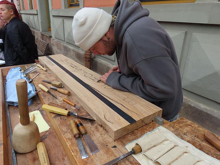 Klassischer Bestandteil der Ausbildung an der Bischofsheimer Holzbildhauerschule ist das Schriftschnitzen, was Schüler beim Markt vorführte. Klassischer Bestandteil der Ausbildung an der Bischofsheimer Holzbildhauerschule ist das Schriftschnitzen, was Schüler beim Markt vorführte.
