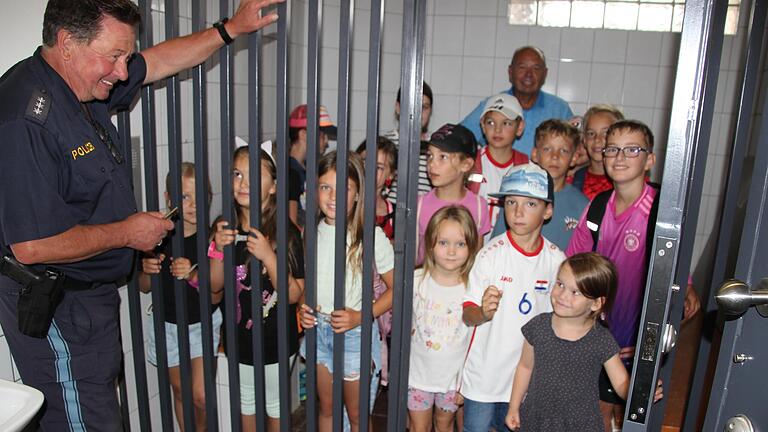 Hauptkommissar Hubert Koch (l.) brachte den Kindern vom Ferien-programm des SPD-Ortsvereins Elfershausen die Aufgaben der Polizei nahe. Der kurze Aufenthalt in der Gefängniszelle hatte für einige einen gruseligen Beigeschmack.       -  Hauptkommissar Hubert Koch (l.) brachte den Kindern vom Ferien-programm des SPD-Ortsvereins Elfershausen die Aufgaben der Polizei nahe. Der kurze Aufenthalt in der Gefängniszelle hatte für einige einen gruseligen Beigeschmack.