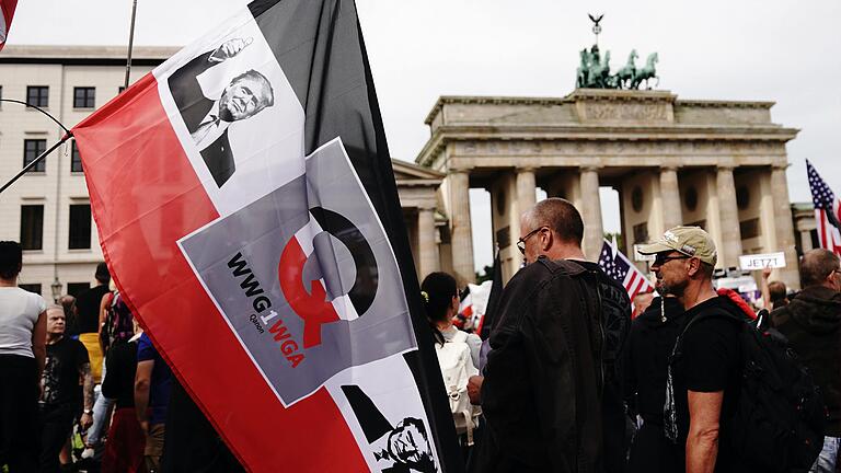 Erkennungszeichen für QAnon auf der Demo gegen Corona-Maßnahmen im August 2020 in Berlin: eine Fahne mit dem Bild des mittlerweile abgewählten US-Präsidenten Donald Trump auf sowie mit dem 'Q'&nbsp; und dem Schriftzug 'WWG1WGA '(für 'Where We Go one We Go All').