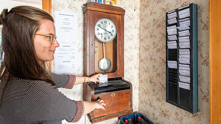 Mit einer 100 Jahre alten Stechuhr halten die Bauherren, hier Isabell Ebner, die Eigenleistung fest. In Geldersheim sanieren sie und ihr Mann Frank einen alten Bauernhof.