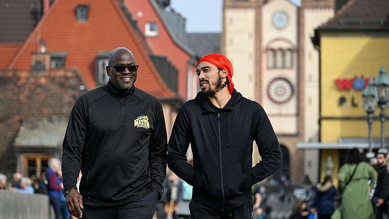 Der Spieler der Würzburg Baskets Otis Livingston II (rechts) hat Besuch von seinem Vater, der TV-Legende  Otis Livingston (links) aus den USA. Hier sind die beiden beim Stadtrundgang auf der Alten Mainbrücke.