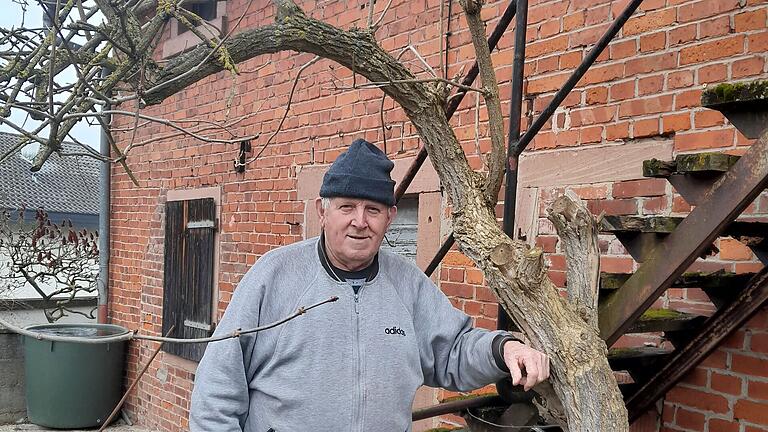 Arnold Herbert aus Obersinn am Holunderbaum in seinem Hof, der ihn auf die Idee zum Obersinner Roter Tod gebracht hat.